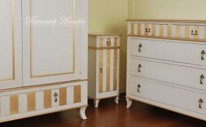 Classic wooden cabinet with white lacquered finish and hand-applied gold leaf